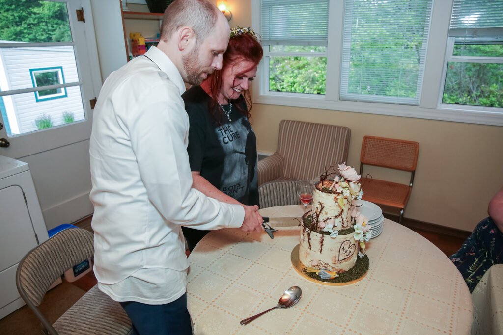 bride and groom cutting their elopement cake in their PJs