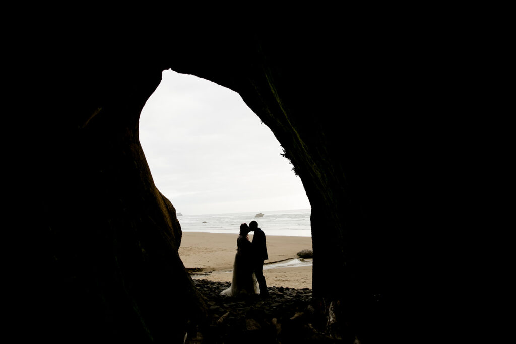 bride and groom inside a cave during their hug point elopement